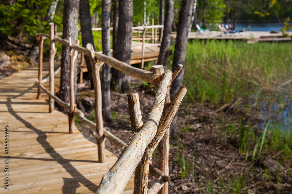 Fototapeta premium Wooden paths along the lake in the spring forest of Karelia