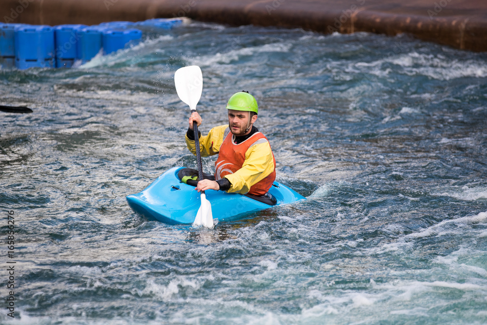 Naklejka premium Man with paddle in a kayak on the water