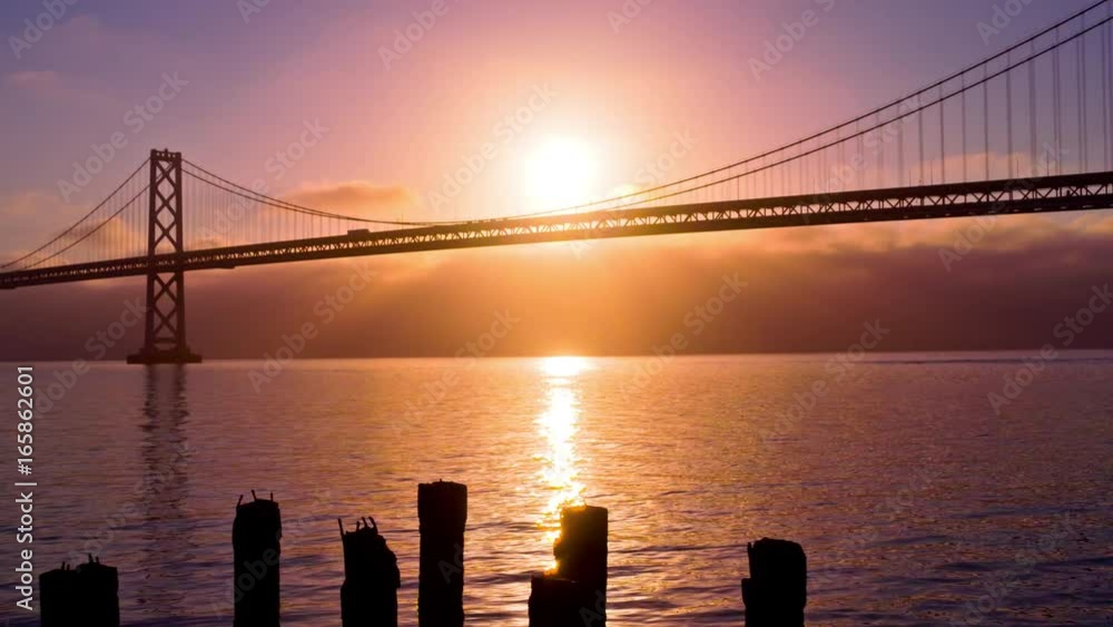 The sun rises from behind the Bay Bridge in San Francisco. The sun rises from behind the Bay Bridge in San Francisco.