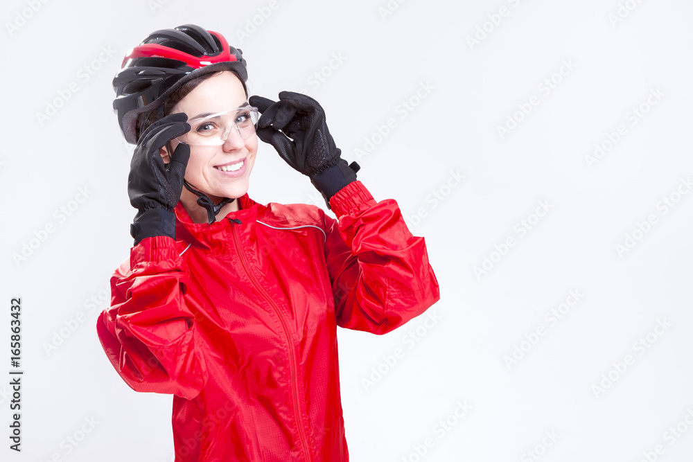 Sport Concepts and Ideas. Portrait of Smiling Caucasian Female Cycling Athlete Posing Equipped in Professional Outfit in Studio. Sport Concepts and Ideas. Portrait of Smiling Caucasian Female Cycling Athlete Posing Equipped in Professional Outfit in Studio.