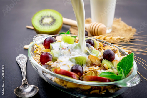 Healthy bowl of muesli, fruit, nuts and milk for a nutritious breakfast photo