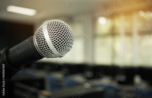 Microphone on abstract blurred of speech in seminar room or speaking conference hall light, computer bokeh background photo