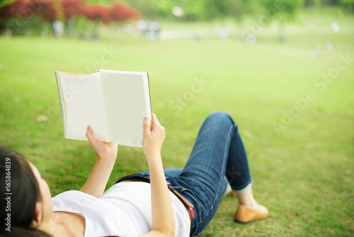 beautiful girl with book on the grass