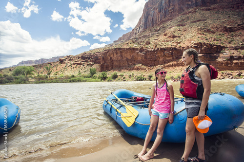 Smiling child and adult women ready to board a large inflatable raft as they travel down the scenic Colorado River near Moab, Utah and Arches National Park
