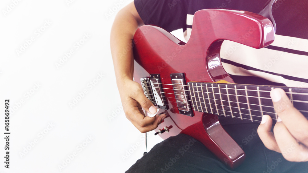 Fototapeta premium A man playing red electric guitar