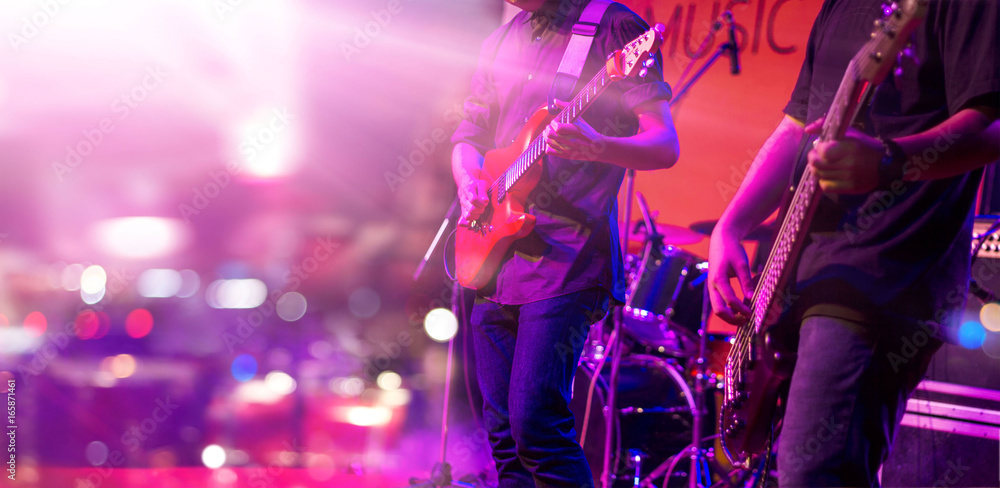 Obraz premium Gitarzysta i kolorowe oświetlenie na scenie, nieostrość
