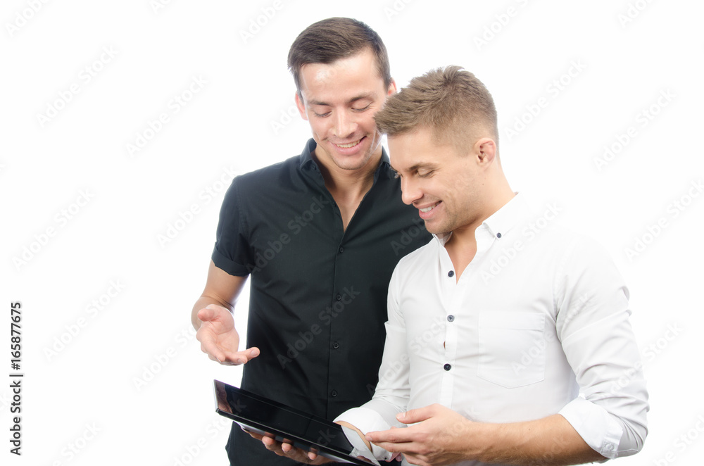 Two attractive students and a tablet. White background. Two attractive students and a tablet. White background.
