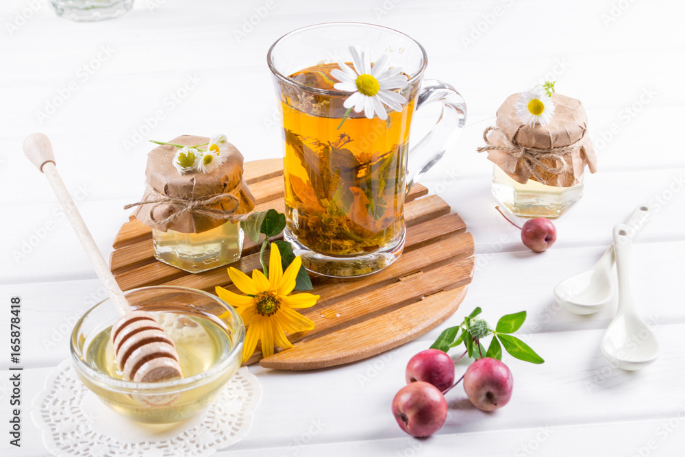 A healthy Cup of herbal tea, a jar of honey and wild flowers. A healthy Cup of herbal tea, a jar of honey and wild flowers.
