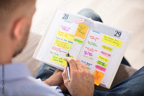 Man Writing Important Notes In Diary