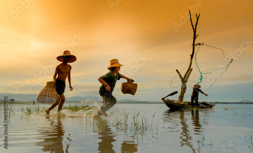 Foto Children boy and girl run catching fish, Fisherman fishing nets on boat at lake,