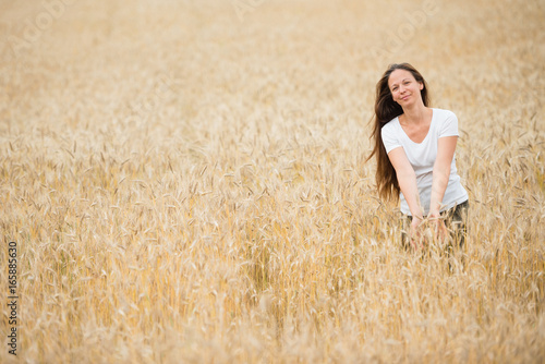 Young woman in white shirt standing in the wheat field