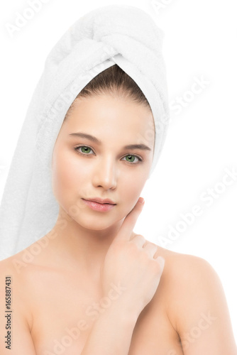 Beautiful young brunette woman with clean face and towel on her head. Beauty spa model girl perfect fresh clean skin. Youth and skin care concept. Isolated.