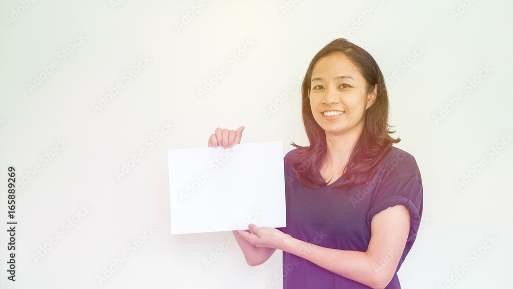 Casual Asian woman holding white sign with copy space Casual Asian woman holding white sign with copy space