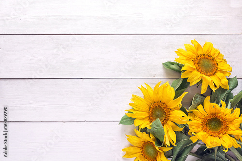 Fototapeta Naklejka Na Ścianę i Meble -  Background with a bouquet of yellow sunflowers on  white painted wooden planks. Space for text.