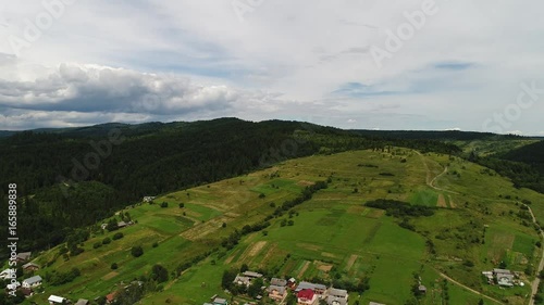 aerial view agriculture field and mountains. summer day. Summer day landscape.  Flying over the beautiful rural landscape. Aerial camera shot. 