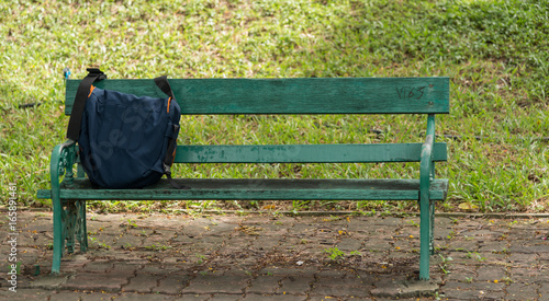 Men's accessories with bags on wooden chair in graden background