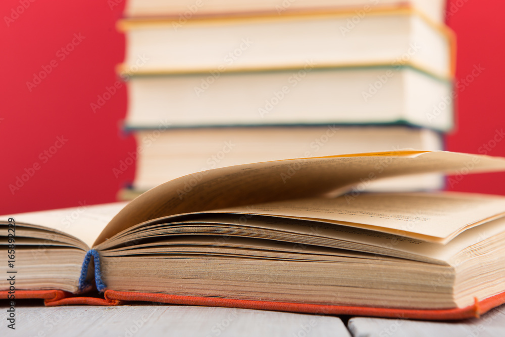 Fototapeta premium education and wisdom concept - open book on wooden table, color background