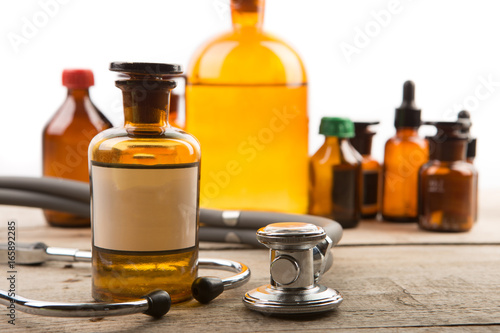 Pharmacy container with blank label and vintage medical bottles on the background