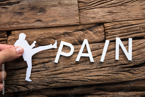Bild auf Leinwand Hand Holding Paper Businessman Kicking Word Pain