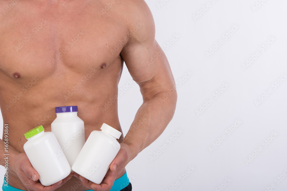 Sports nutrition and a healthy lifestyle. A man is holding a jar of pills. Sports nutrition and a healthy lifestyle. A man is holding a jar of pills.