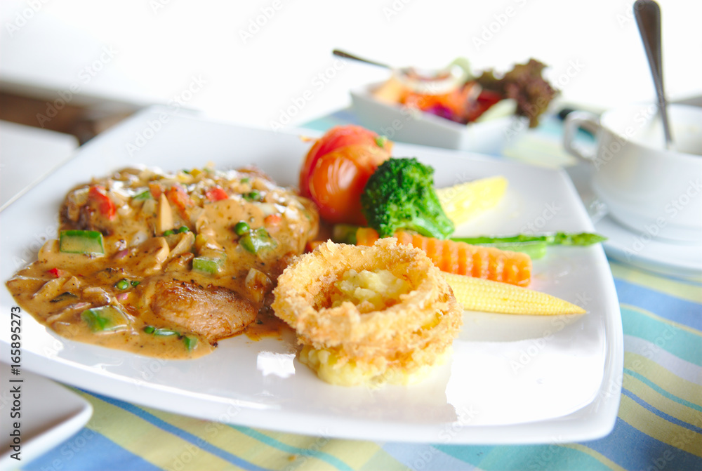 Steak with fried union and vegetable in white plate. Steak with fried union and vegetable in white plate.