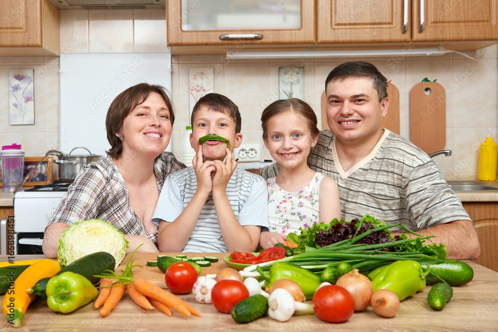 family portrait in kitchen interior at home, fresh fruits and vegetables, healthy food concept, woman, man and children cooking and having fun family portrait in kitchen interior at home, fresh fruits and vegetables, healthy food concept, woman, man and children cooking and having fun