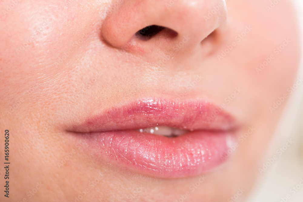 Naklejka premium Close-up of woman's lips with natural lipstick make up. macro lipgloss make-up