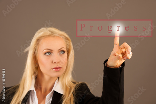 Beautiful business woman presing avirtual button on a transparent board photo