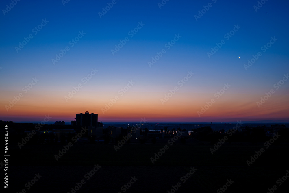 Early dawn in the city with the moon Early dawn in the city with the moon