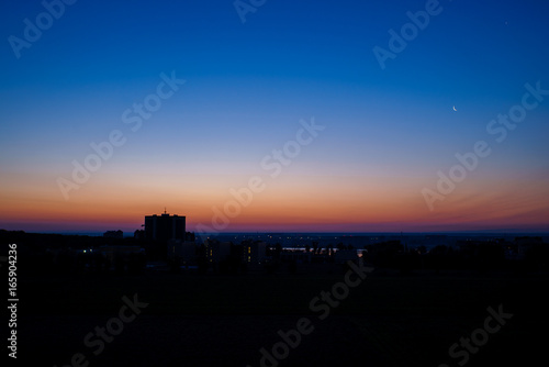 Early dawn in the city with the moon