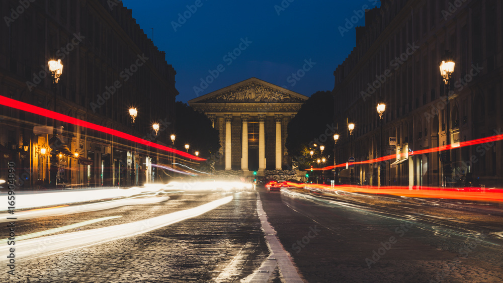 La Madeleine church at night in Paris with cars light trails