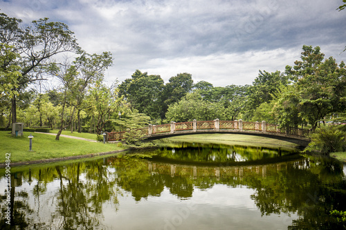 Bridge across the lake in green Garden park nature © Wutthipong53