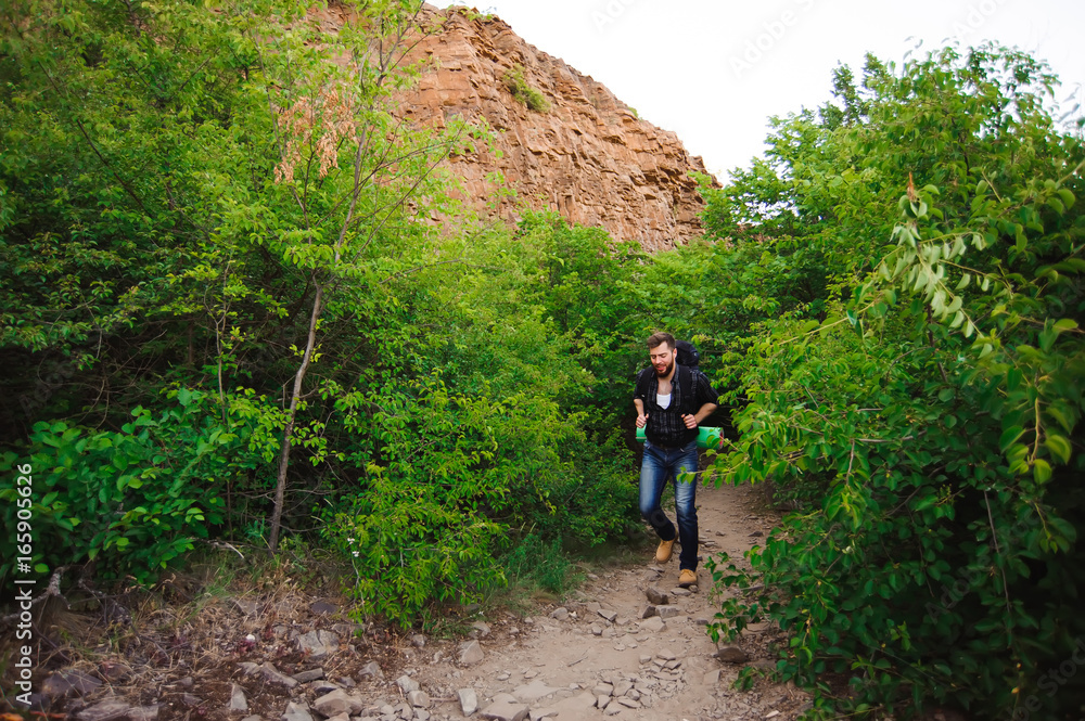 Traveler man walking with backpack in rocky mountains. Travel concept. Traveler man walking with backpack in rocky mountains. Travel concept.