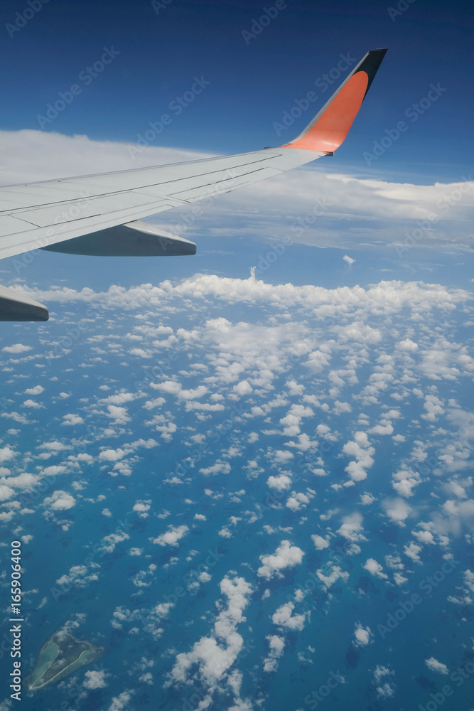 Obraz premium TRANG, THAILAND - MARCH 26, 2017 : AIRBUS A32O-200 AIRPLANE WING WITH LITTLE CLOUD BLUE SKY , AT A HEIGHT OF 10 KM ABOVE SEA LEVEL