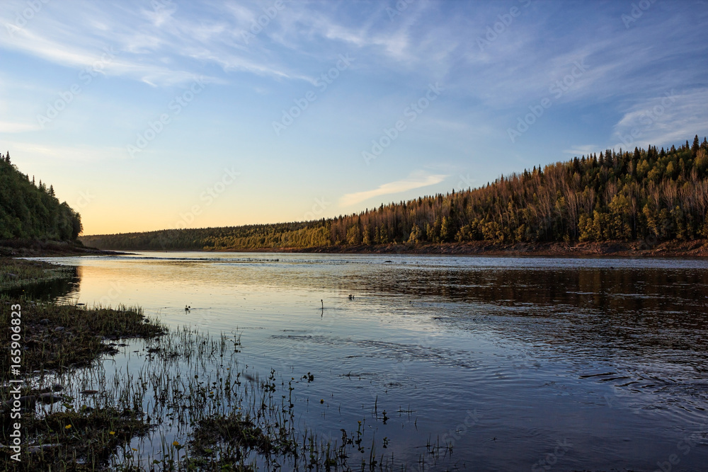 The river bank in the setting sun, calm flow and silence The river bank in the setting sun, calm flow and silence