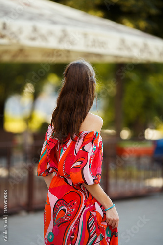 Beautiful model in a bright dress on the street