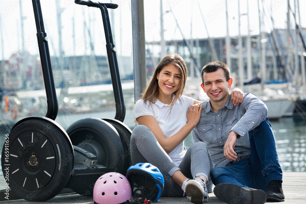 Fototapeta premium Positive tourists couple relaxing near segways