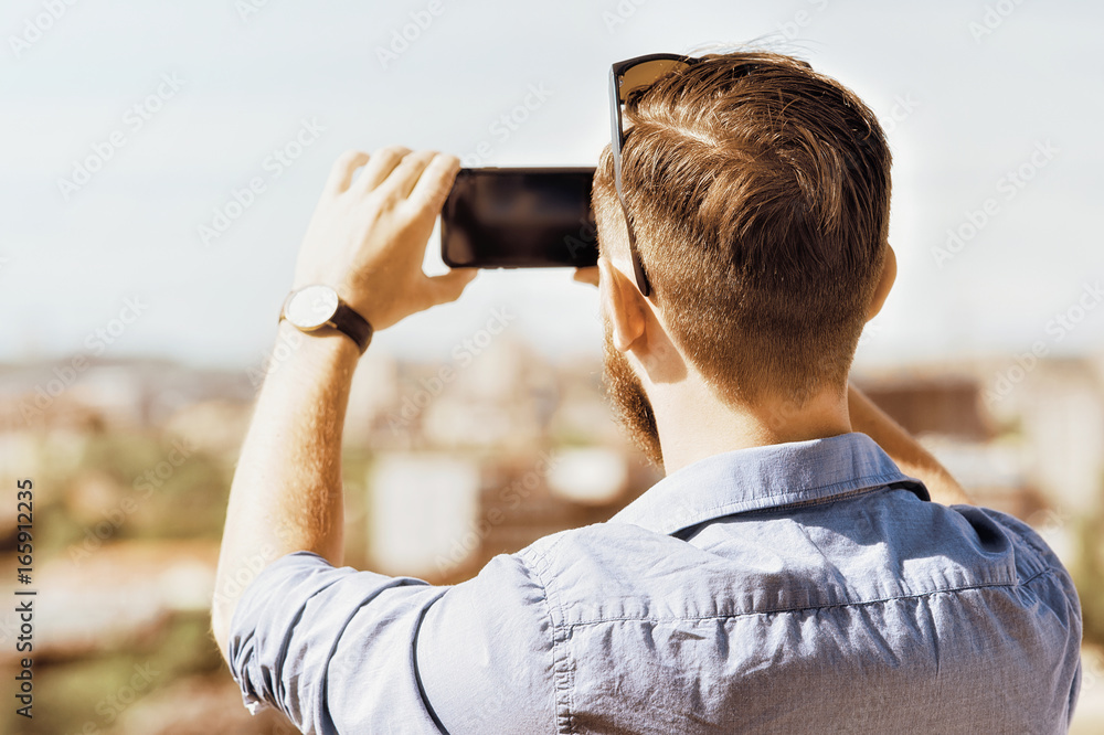 Young caucasian man taking photos on his mobile Young caucasian man taking photos on his mobile