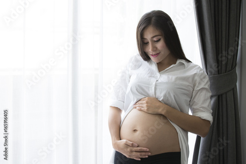 Beautiful pregnant woman showing her belly and carefully holding. Free Download Beautiful pregnant woman showing her belly and carefully holding. - GFXLoad
