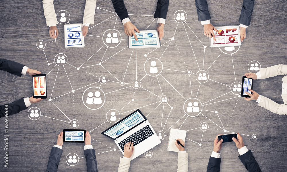 Top view of businesspeople sitting at table and using gadgets