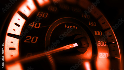 Close up shot of a speed meter in a car with orange light