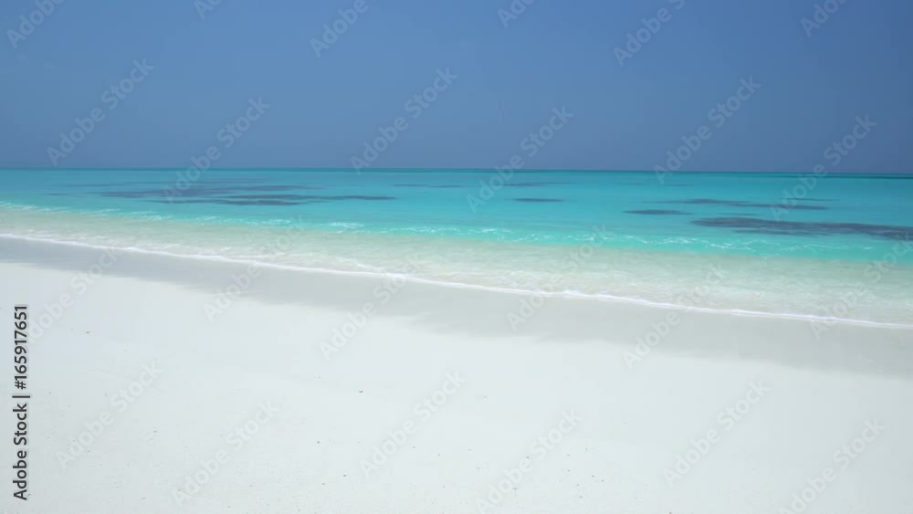 Tropical sandy beach with calm waves on sandbank. Maldivian destination with nobody Tropical sandy beach with calm waves on sandbank. Maldivian destination with nobody