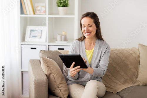 happy woman with tablet pc at home