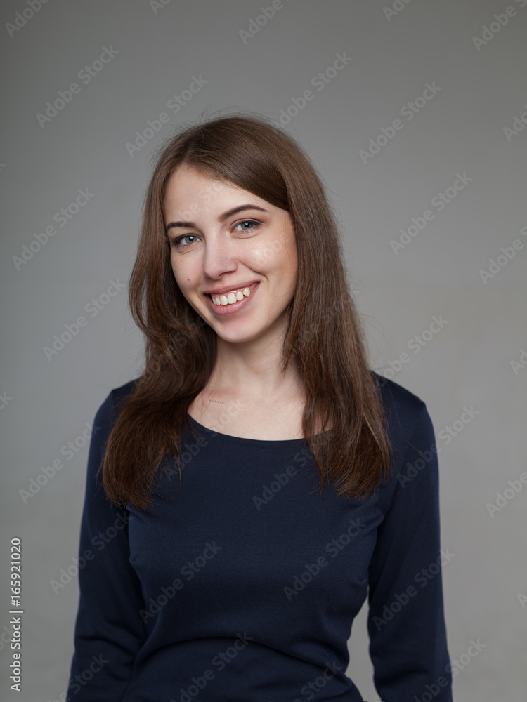 Beautiful brunette in black on a gray background