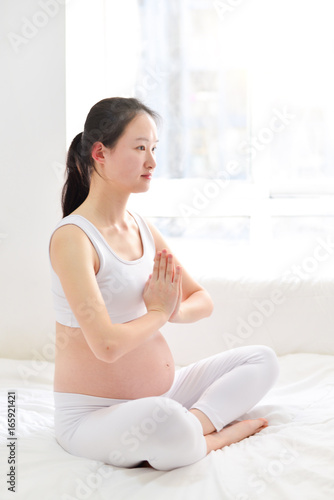 Pre-natal exercises. Beautiful pregnant woman exercising while sitting in lotus position Free Download Pre-natal exercises. Beautiful pregnant woman exercising while sitting in lotus position - GFXLoad