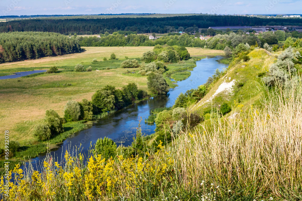 Summertime landscape - river valley of the Siverskyi (Seversky) Donets, the winding river over the meadows between hills and forests, border region of Ukraine near to Russia