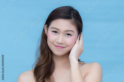 Asian beauty women smile and touching her face on blue background