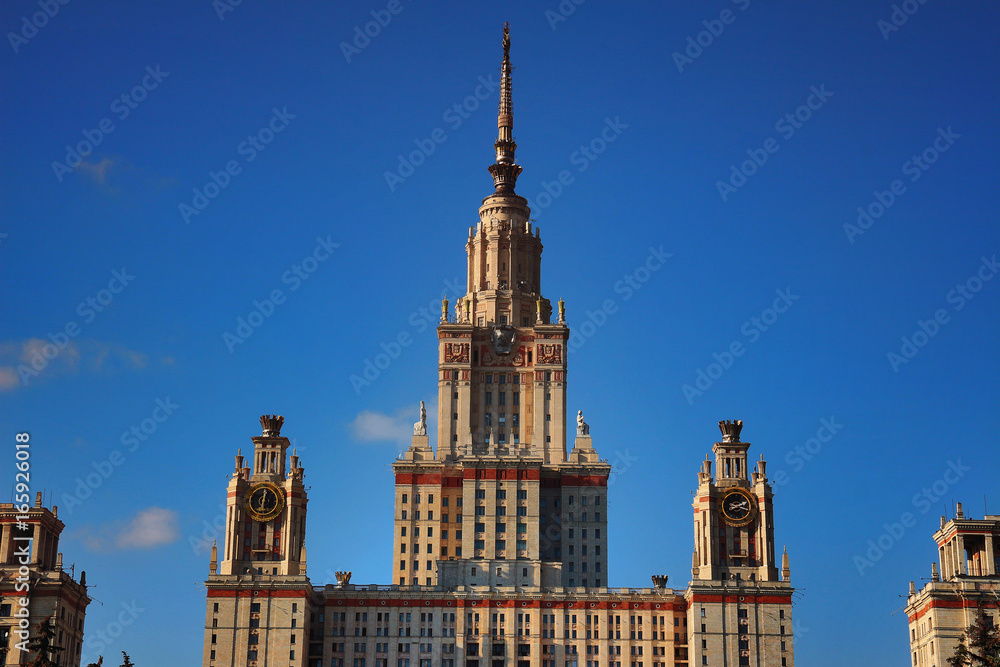 Main building of Lomonosov Moscow State University or MSU at sunset against bright blue sky. Education in Moscow, Russia