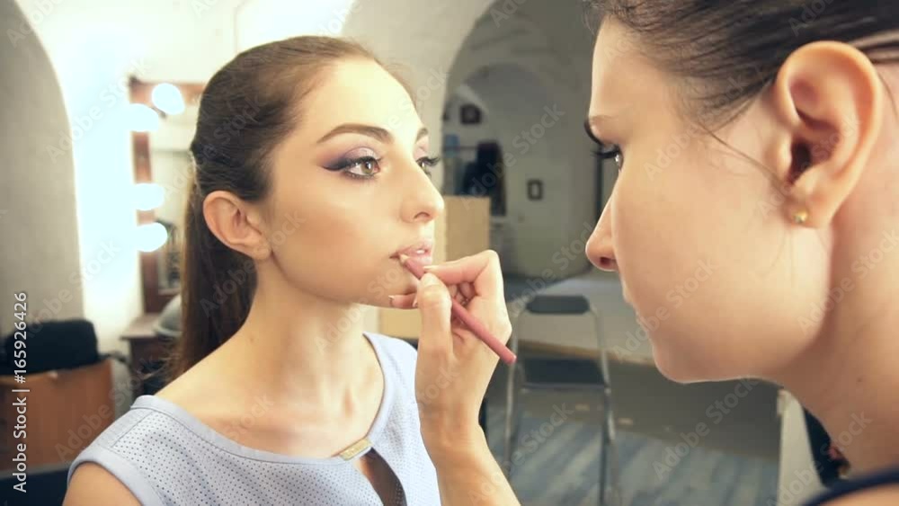 Young beautiful woman applying make-up by make-up artist Young beautiful woman applying make-up by make-up artist