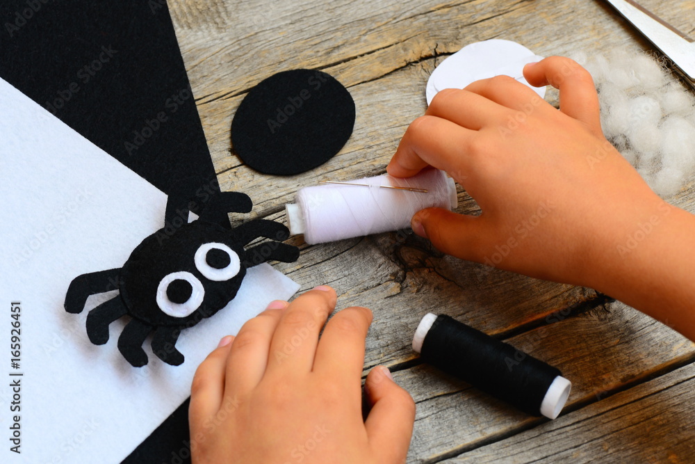 Felt Halloween spider ornament, thread, needle, paper templates, filler,  white and black felt sheets on a